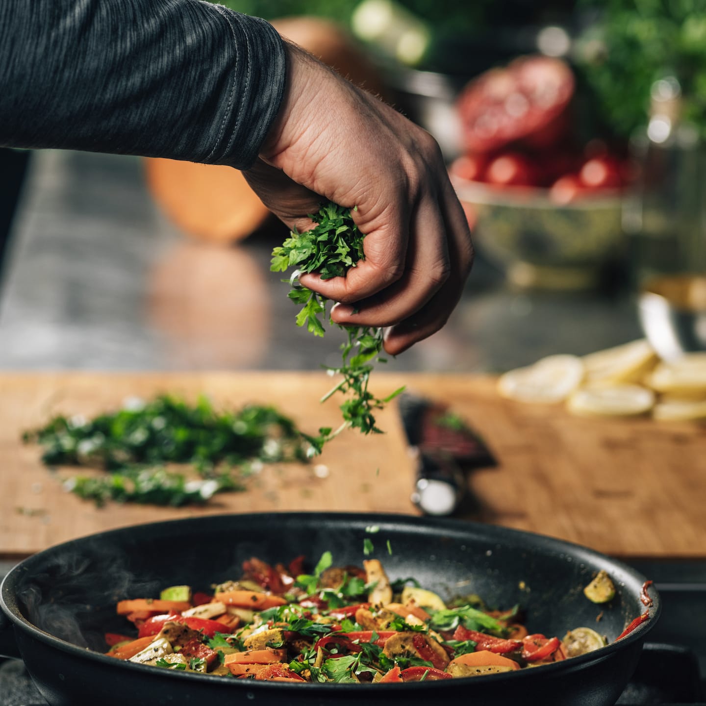 hand adding parsley into frying pan with vegetable 2021 08 27 09 01 22 utc